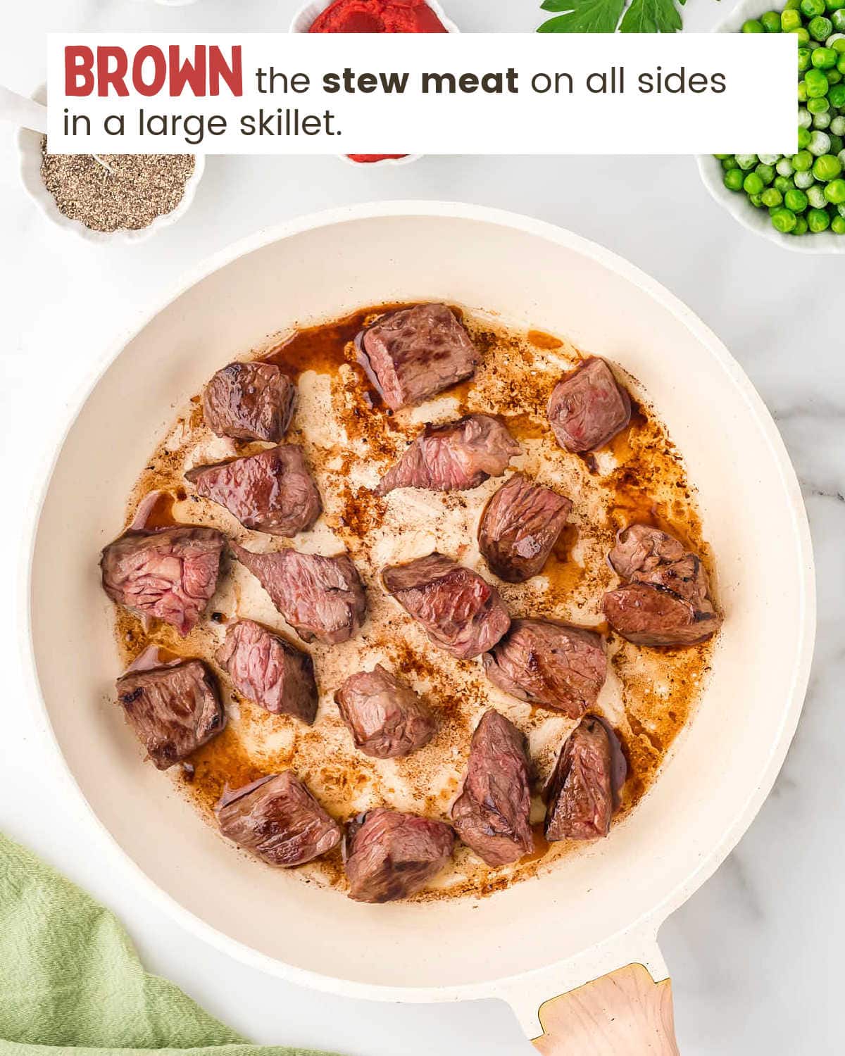 Beef stew meat browning in a skillet.