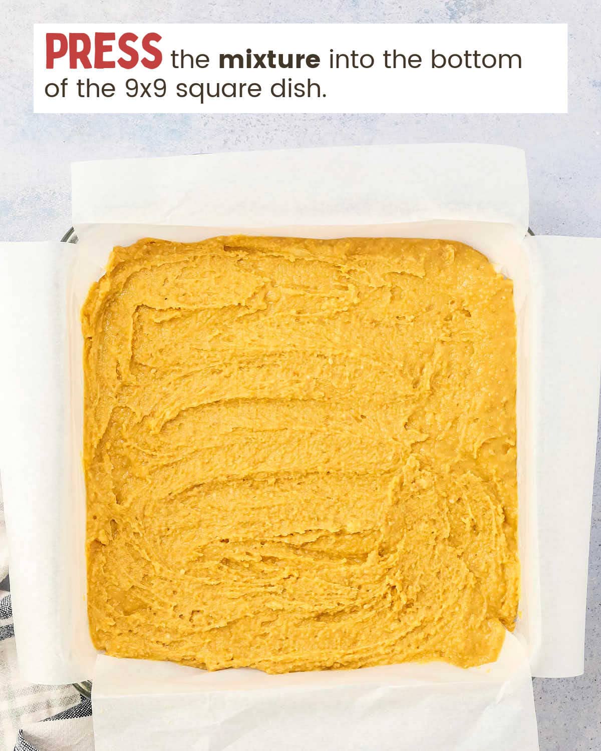 Base layer of peanut butter bars in a dish.