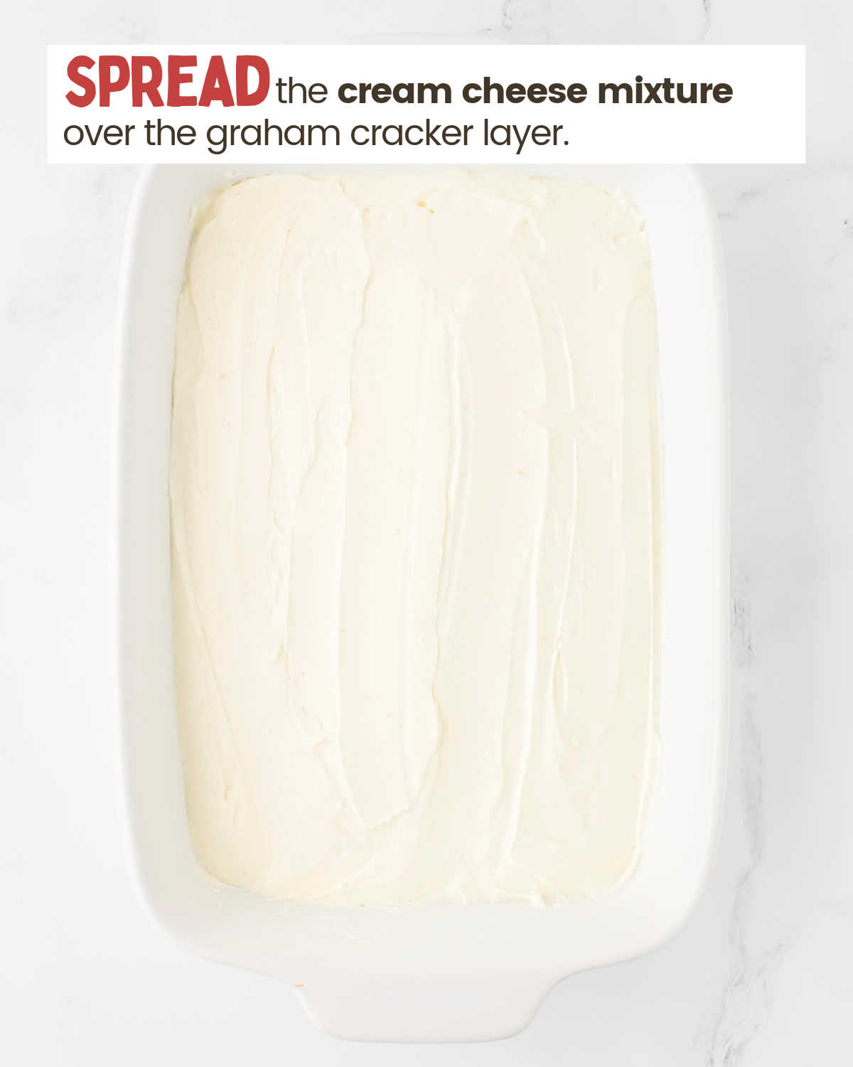 Cream cheese mixture spread as a layer over the graham cracker layer in a baking dish.