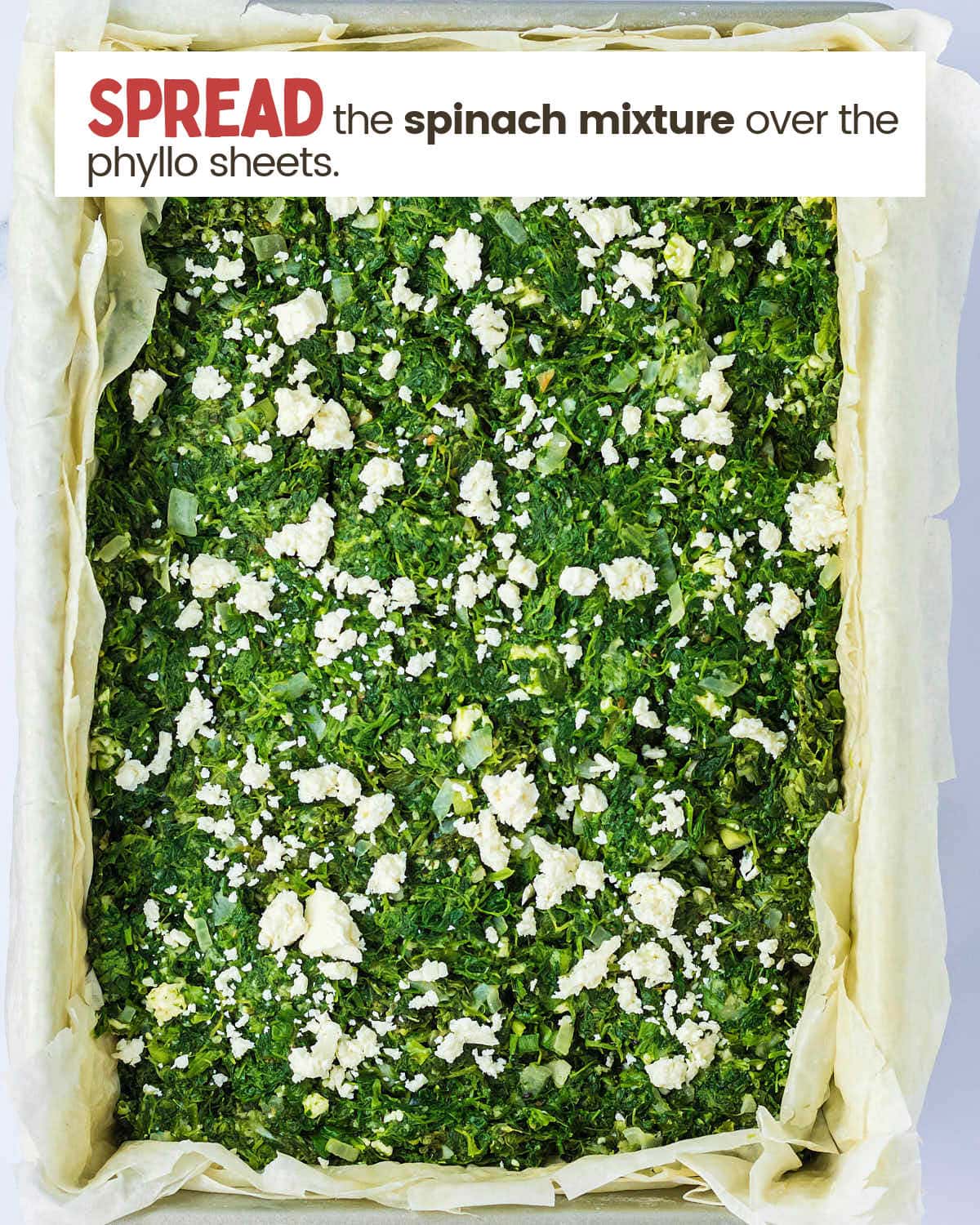Spanakopita filling in a baking dish.