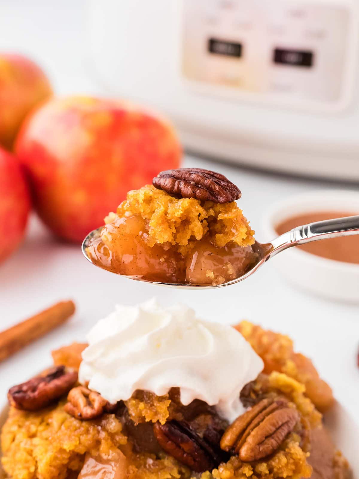 Closeup of a spoonful of a freshly cooked Apple Dump Cake straight out of the Crockpot.