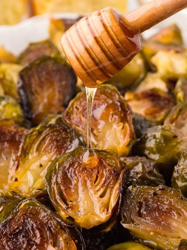 Drizzling honey over Honey Roasted Sweet Brussels Sprout.