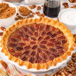 A homemade Pecan Pie in a white baking dish decorate with pecans.