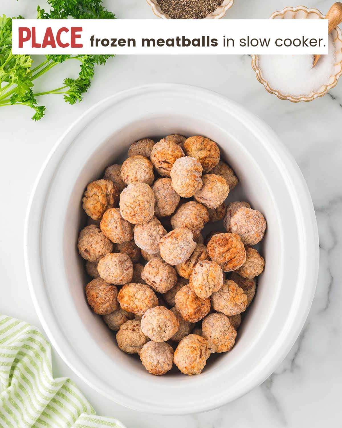 Frozen meatballs in a white slow cooker. 