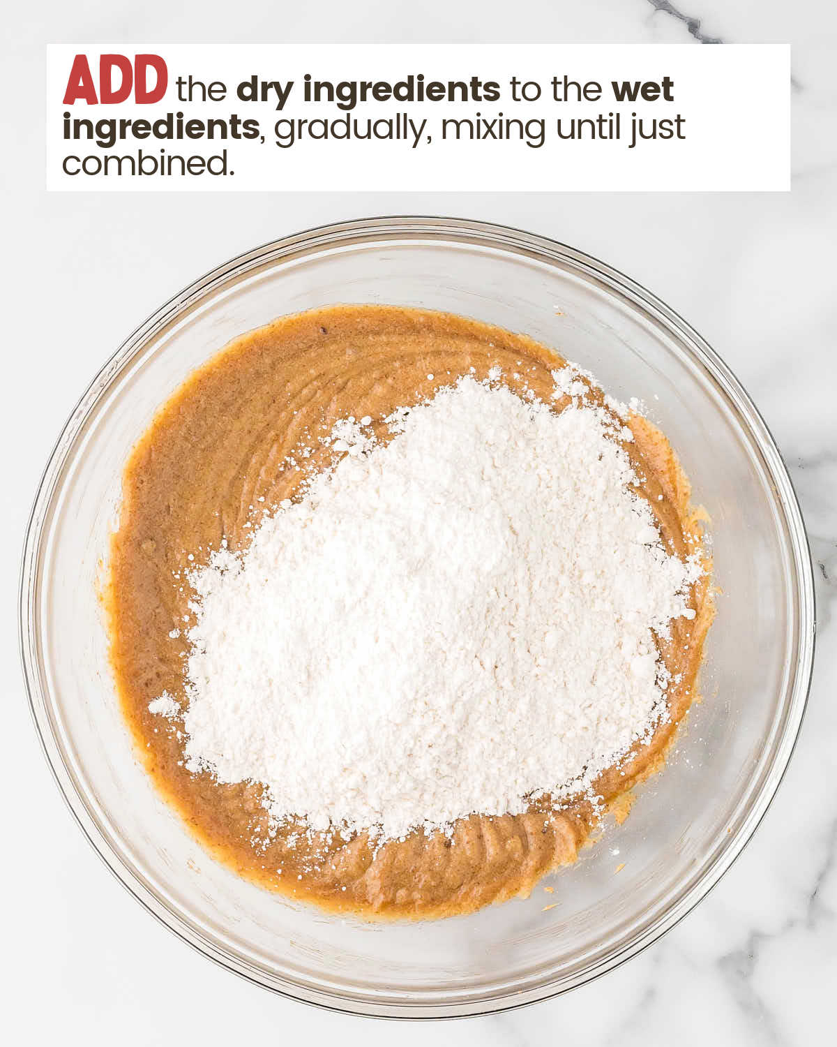 Dry ingredients on top of wet ingredients for chocolate chip cookies in a bowl.