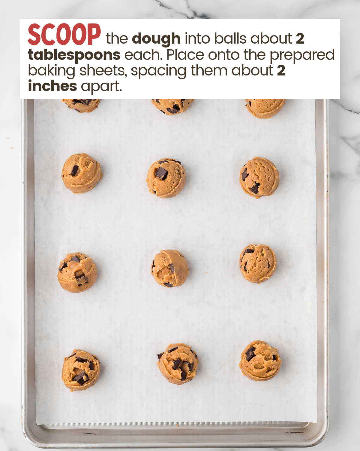 Chocolate chip cookie dough balls on a baking sheet.