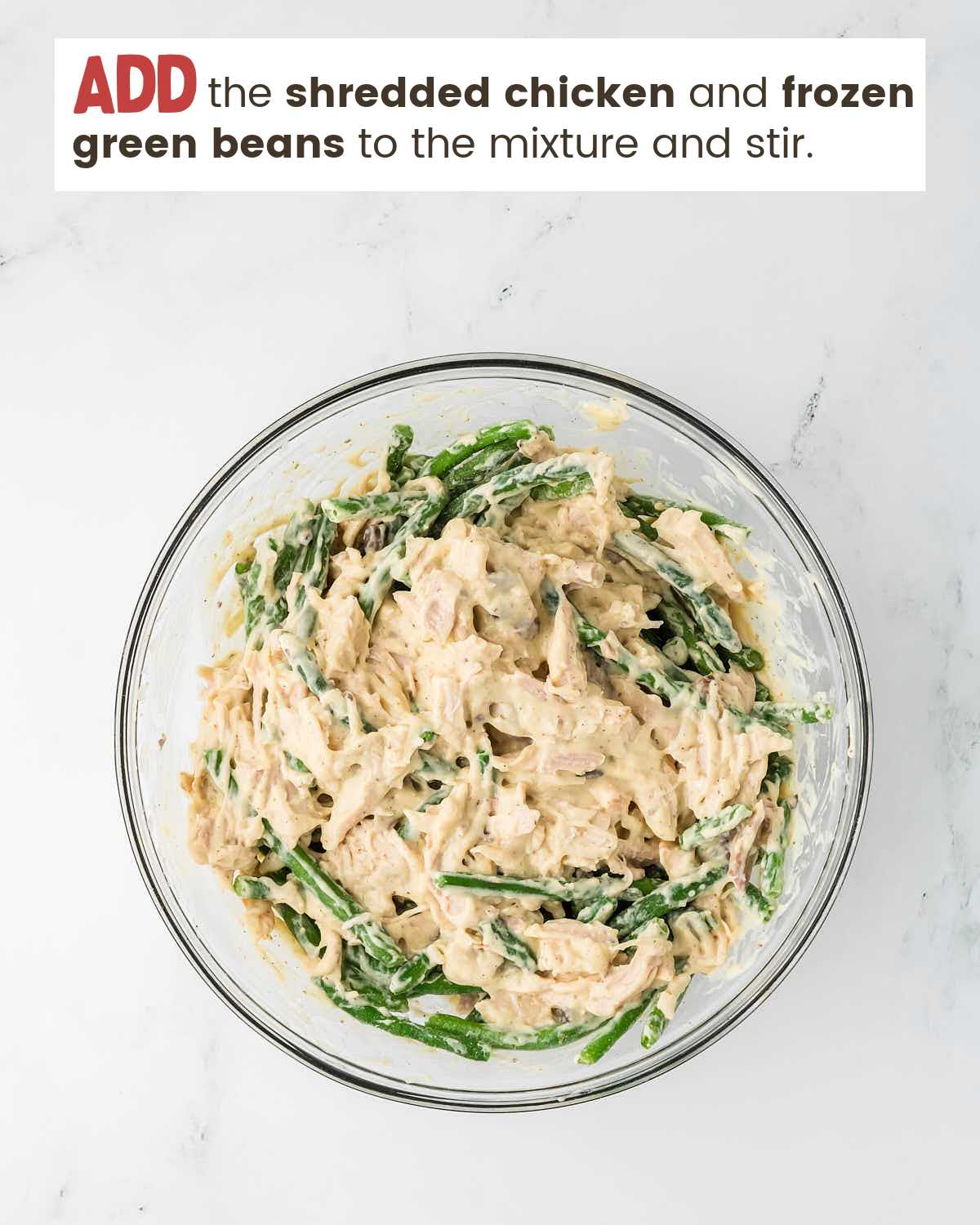 Adding green beans and chicken to the large bowl with whisked ingredients for step 3 in the chicken and stuffing casserole. 