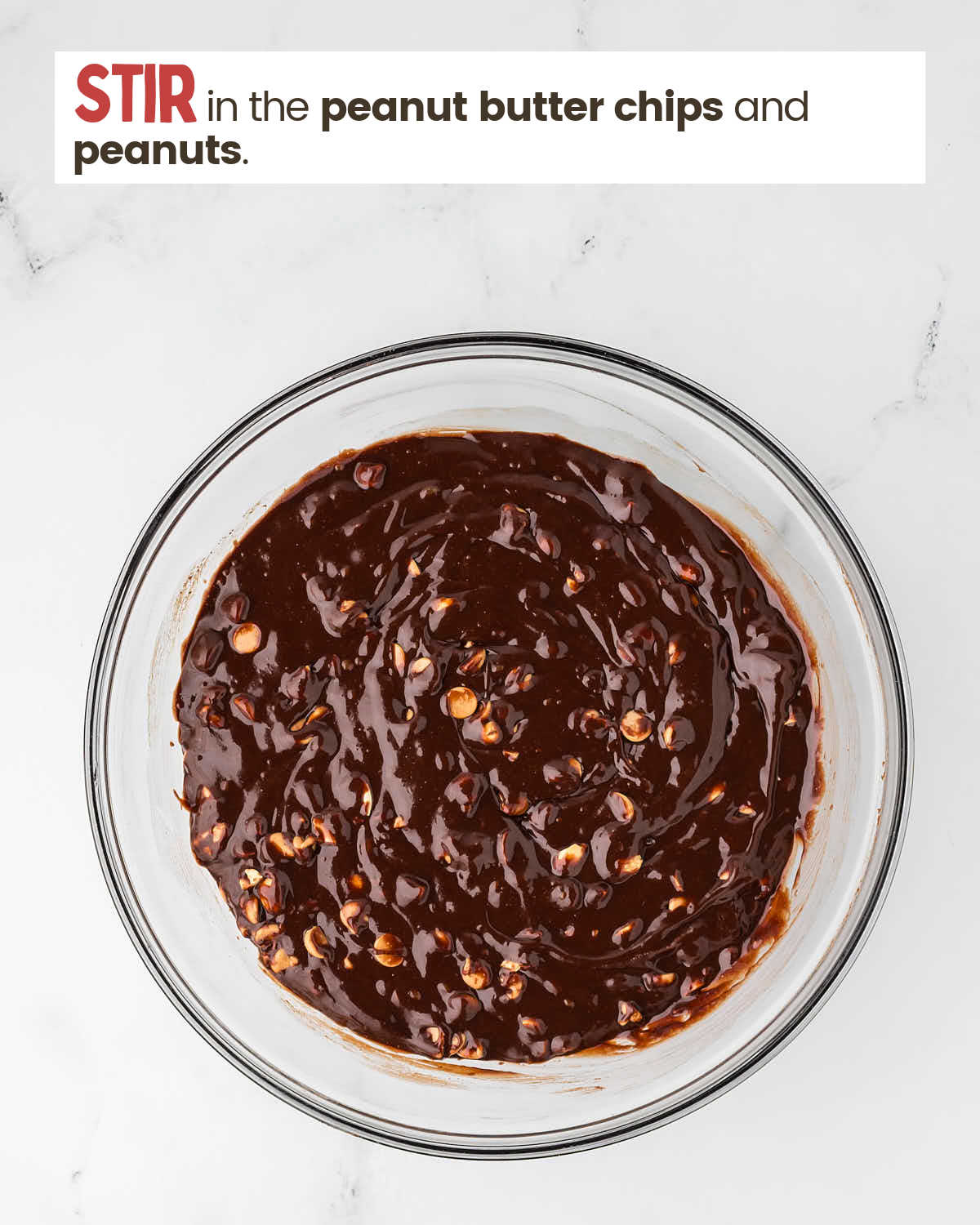 Brownie batter with peanuts and peanut butter chips in a large bowl.