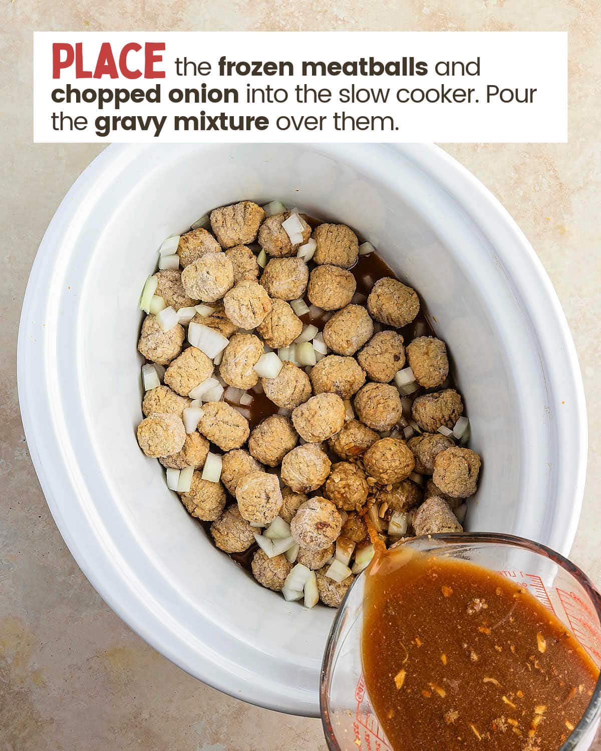 Gravy being poured over frozen meatballs and onions in a slow cooker.