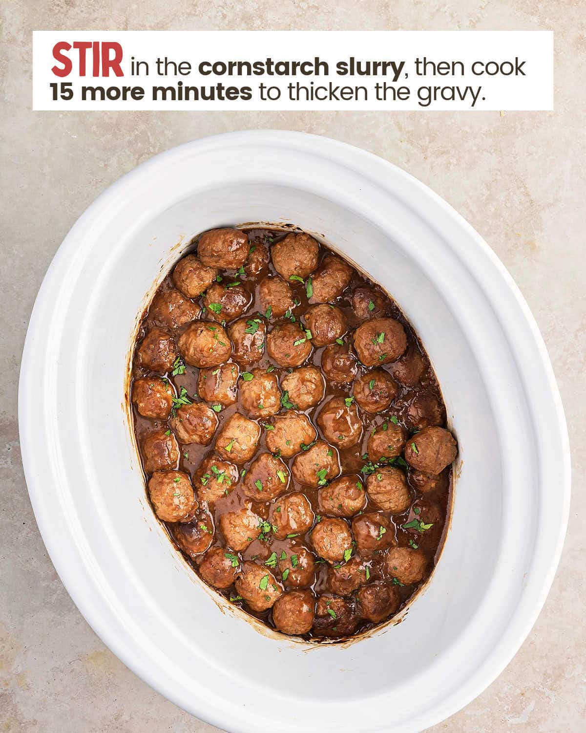 Gravy covers meatballs in a slow cooker.