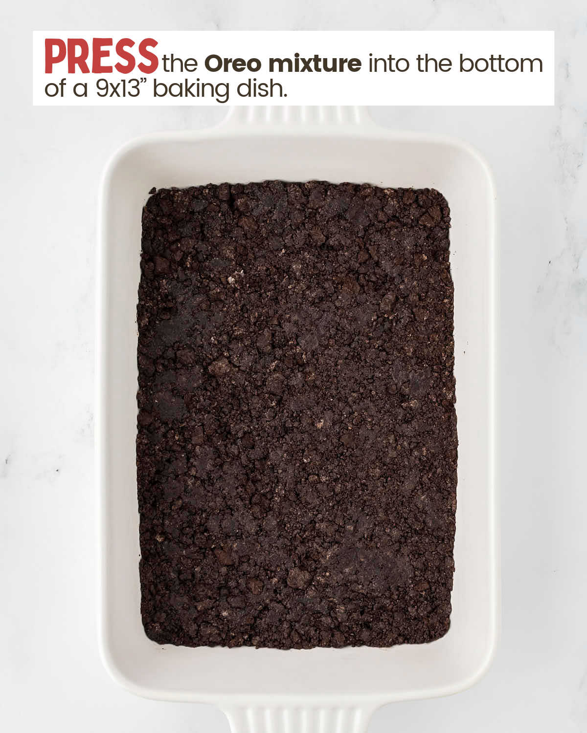Crushed Oreos layer in a baking dish.