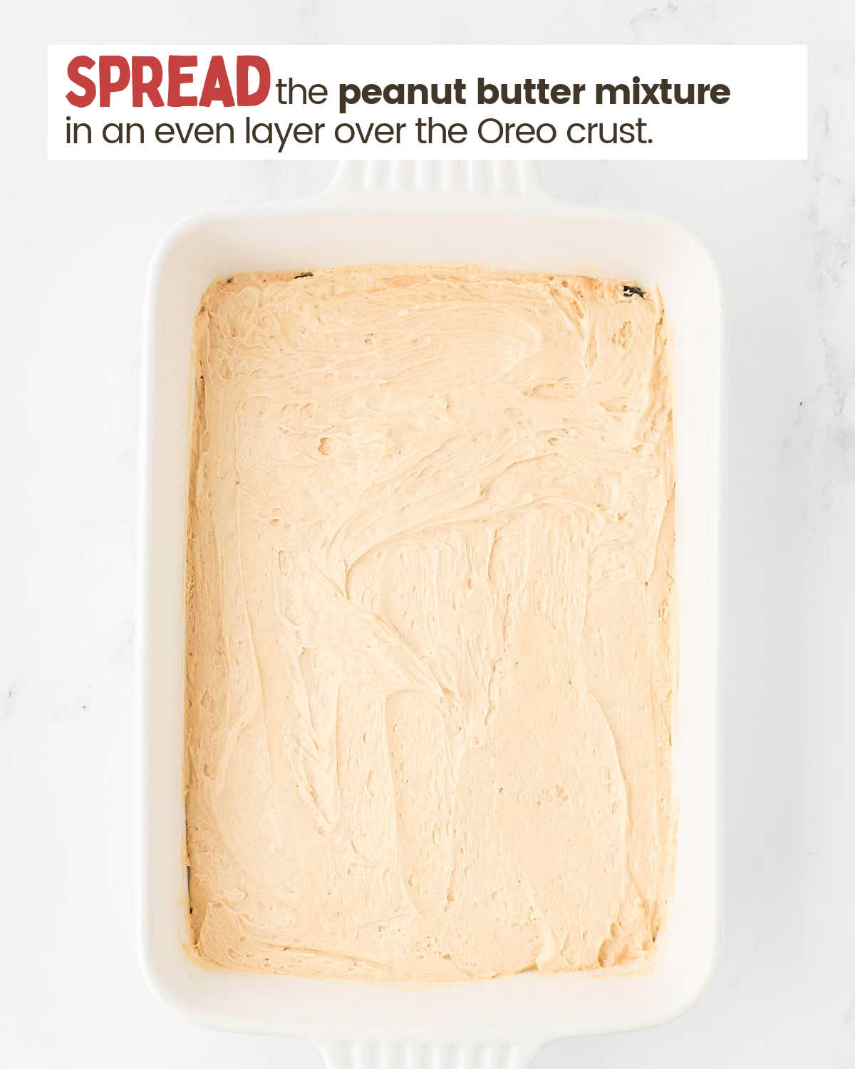 Whipped topping and peanut butter mixture layer in a baking dish.