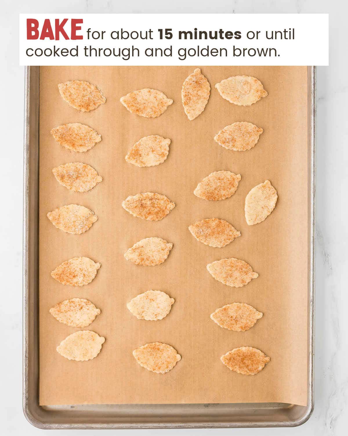 Baked leaf-shaped pieces of pie crust on a baking tray.