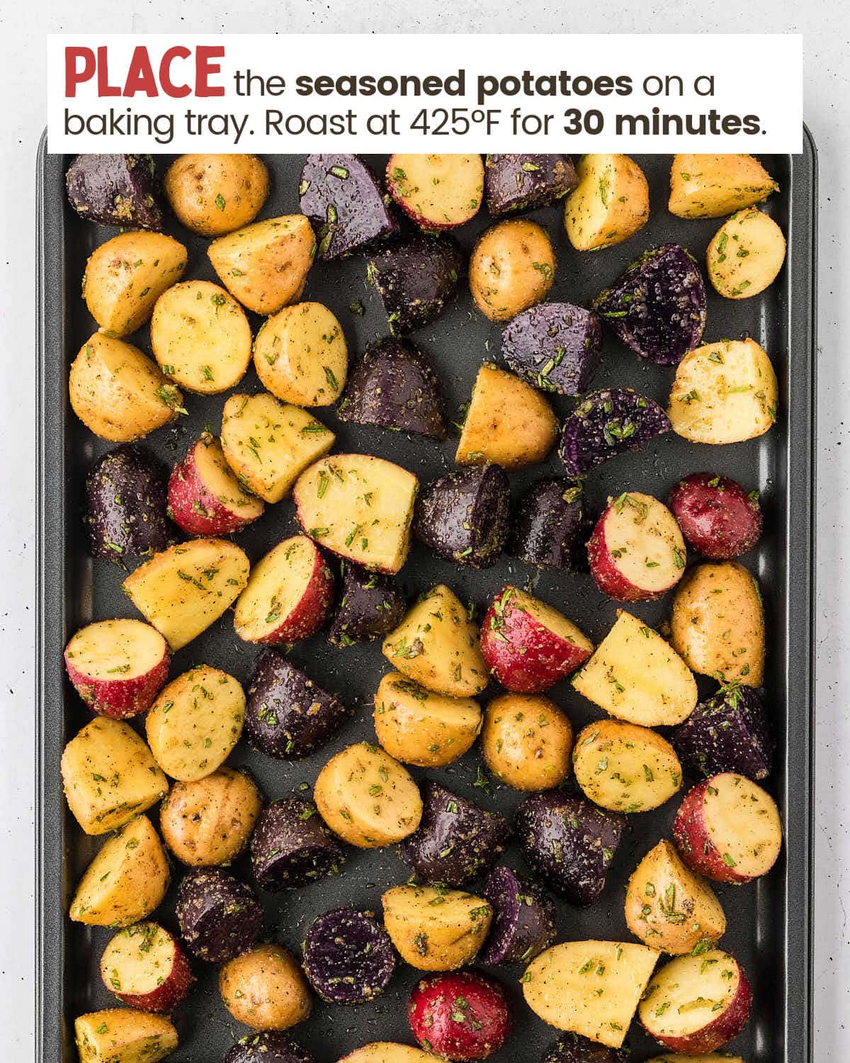 Chopped potatoes and spices on a bake tray.