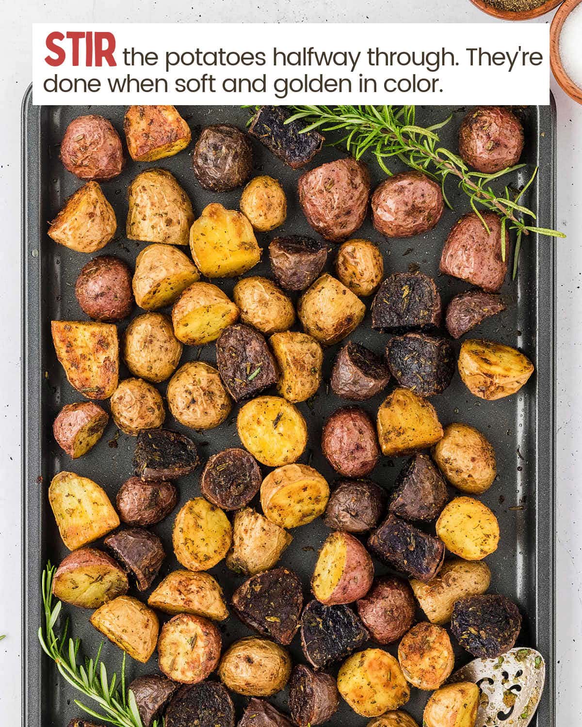 Baked chopped potatoes and spices on a bake tray.