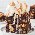 Extra fudgy Chocolate Peanut Brownies topped with vanilla ice cream and drizzled with peanut butter.