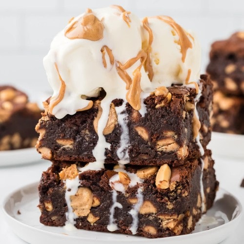 Extra fudgy Chocolate Peanut Brownies topped with vanilla ice cream and drizzled with peanut butter.