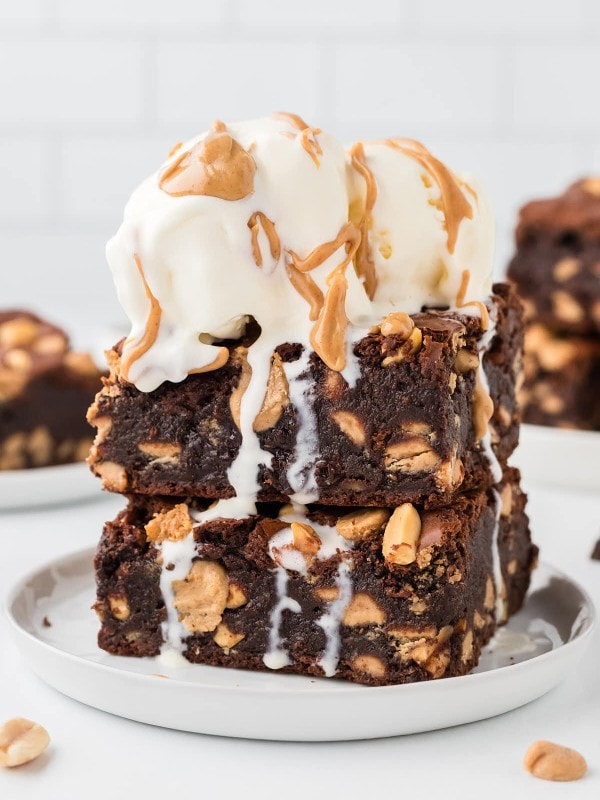 Extra fudgy Chocolate Peanut Brownies topped with vanilla ice cream and drizzled with peanut butter.