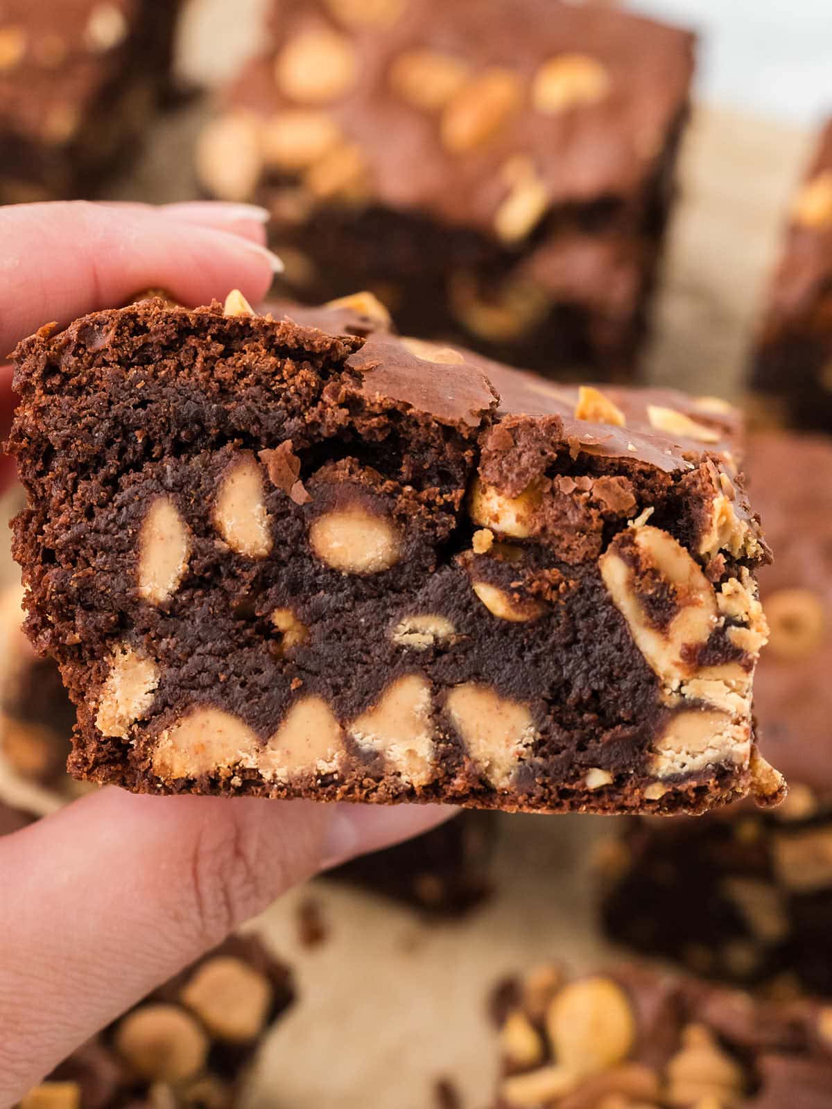 Holding a slice of Chocolate Peanut Butter Brownies.