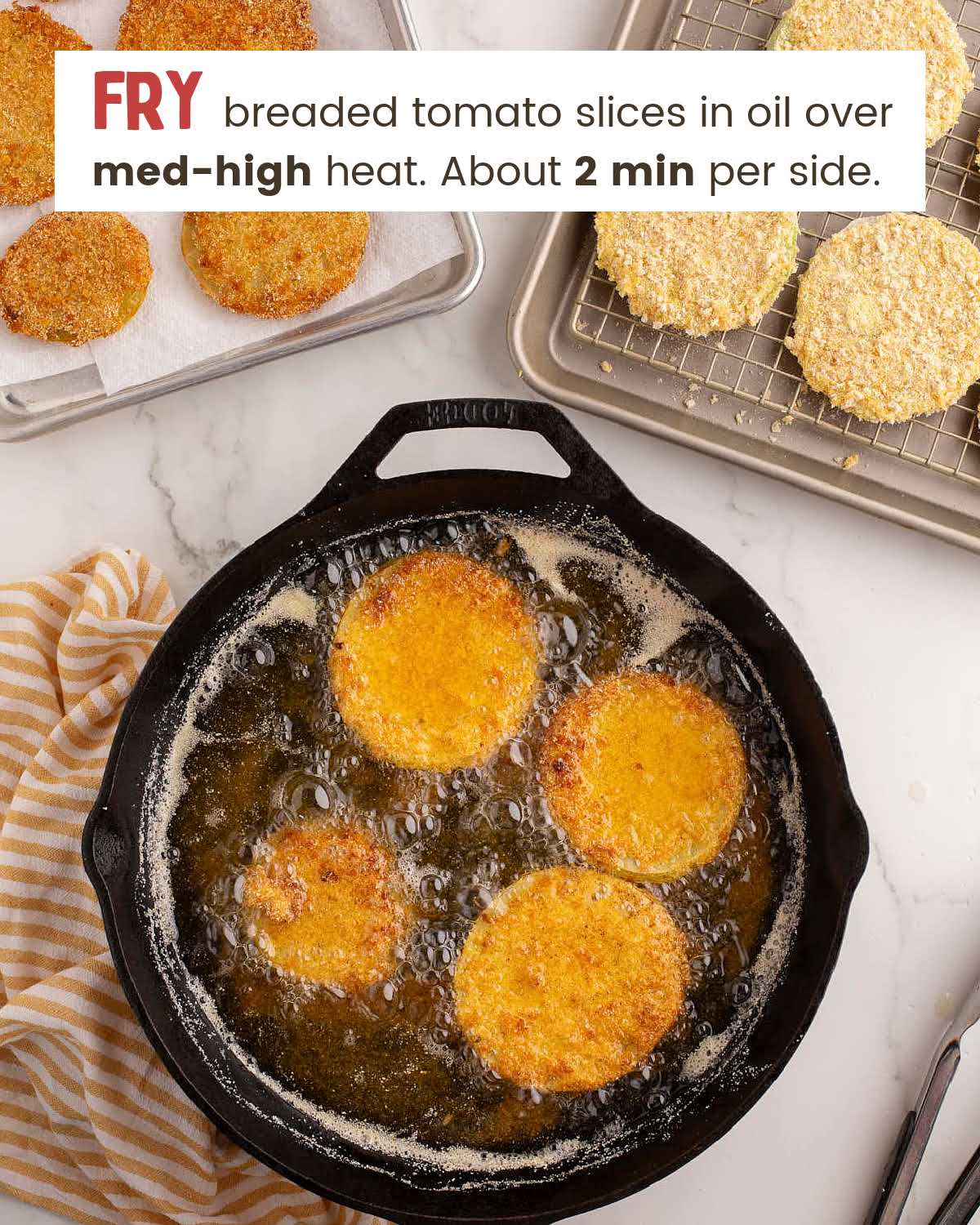 Breaded green tomatoes in a frying pan.