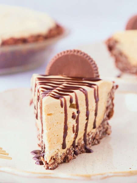 A slice of No-Bake Peanut Butter Pie drizzled with chocolate syrup on top.