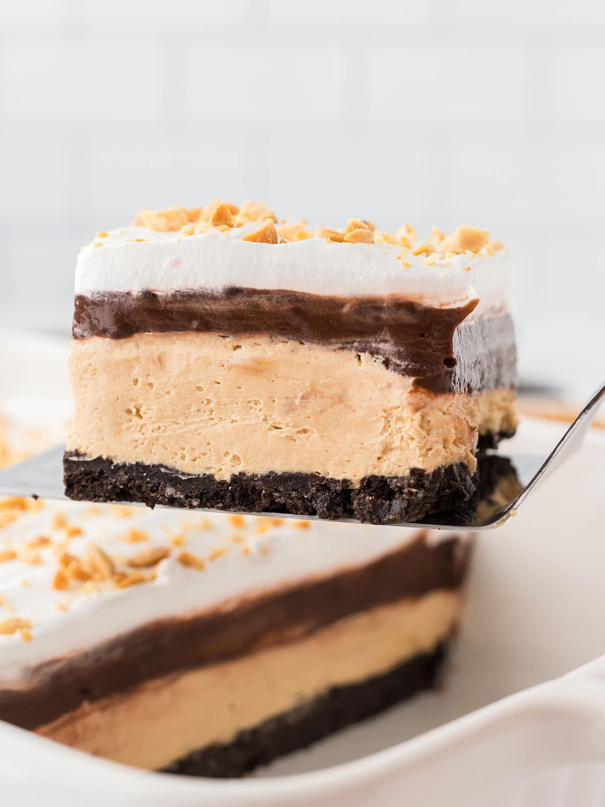 Closeup of a No-Bake Peanut Butter Lasagna on a serving spatula. 