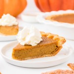 A slice of Pumpkin Pie with whipped cream on top.