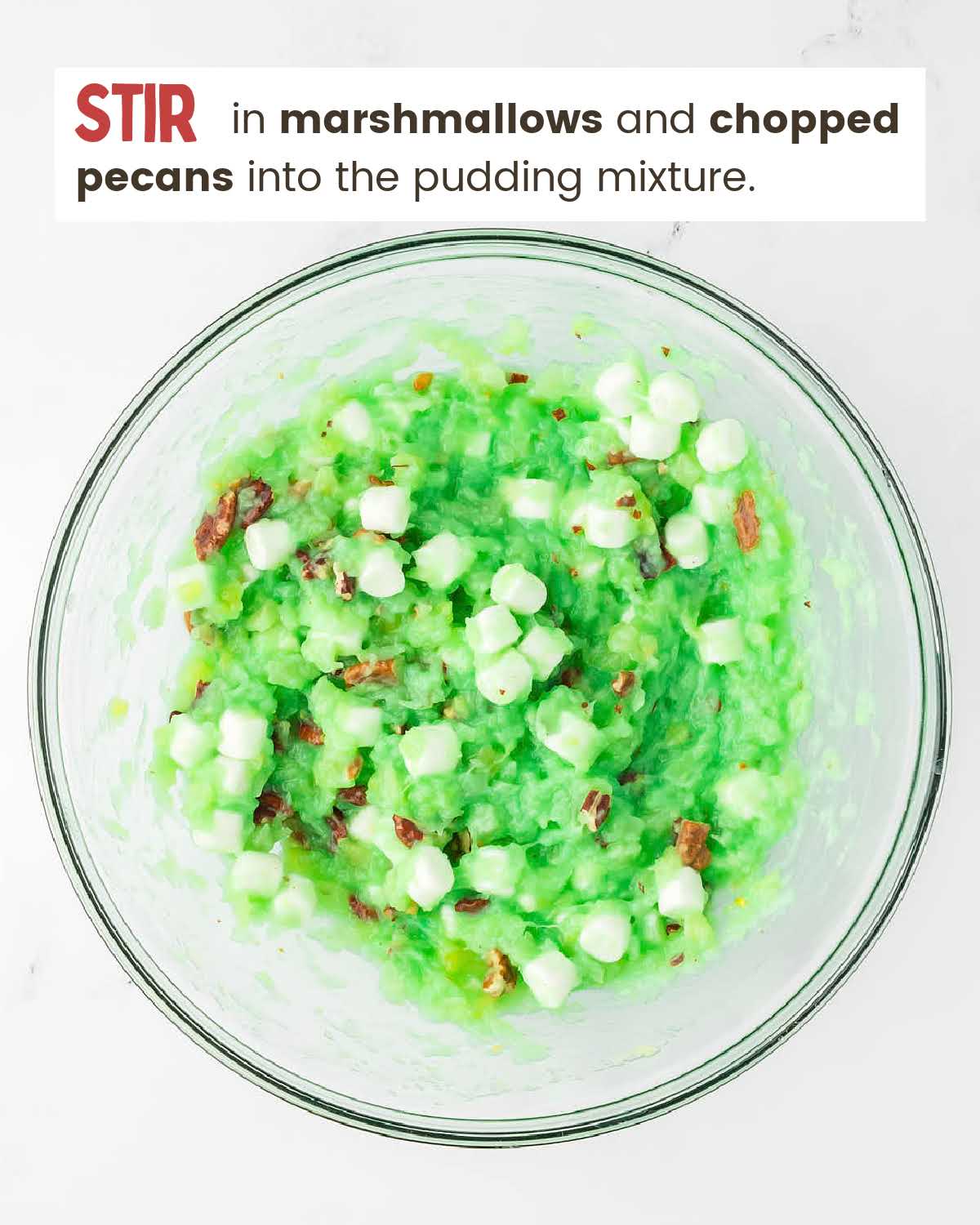 Pudding mix, crushed pineapple, marshmallows, and chopped pecans in a bowl.