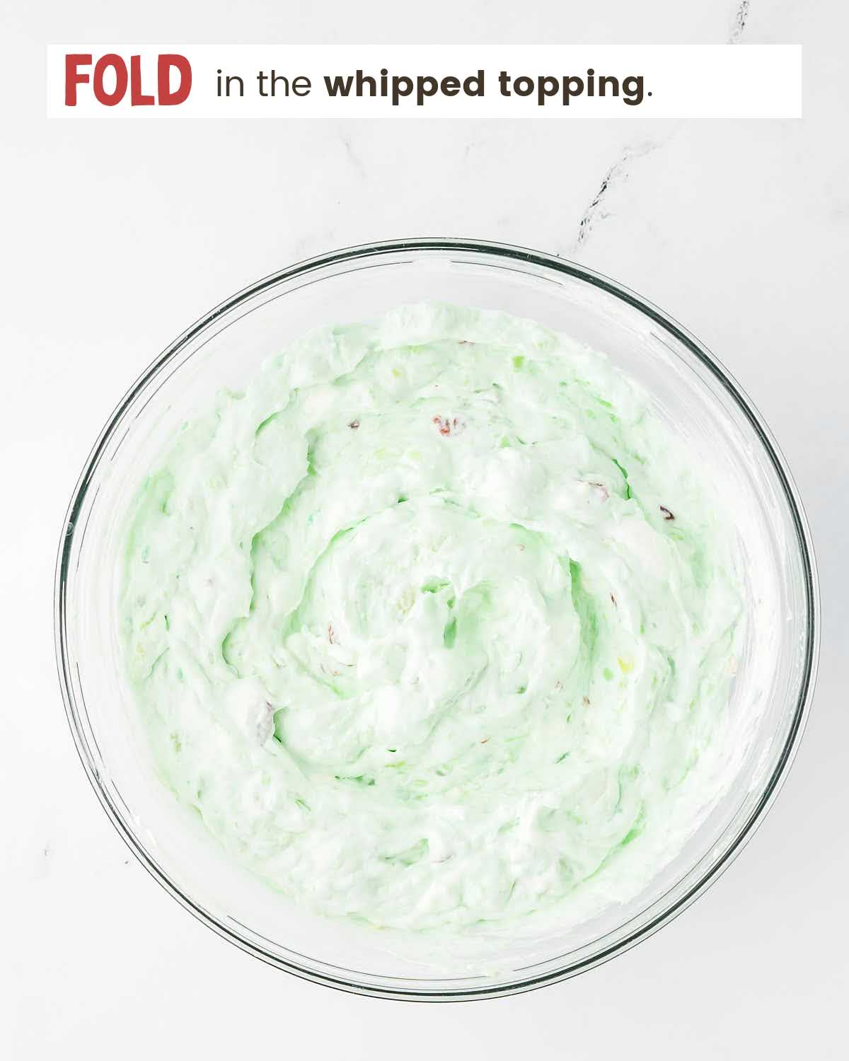 Pudding mixture with whipped topping in a bowl.