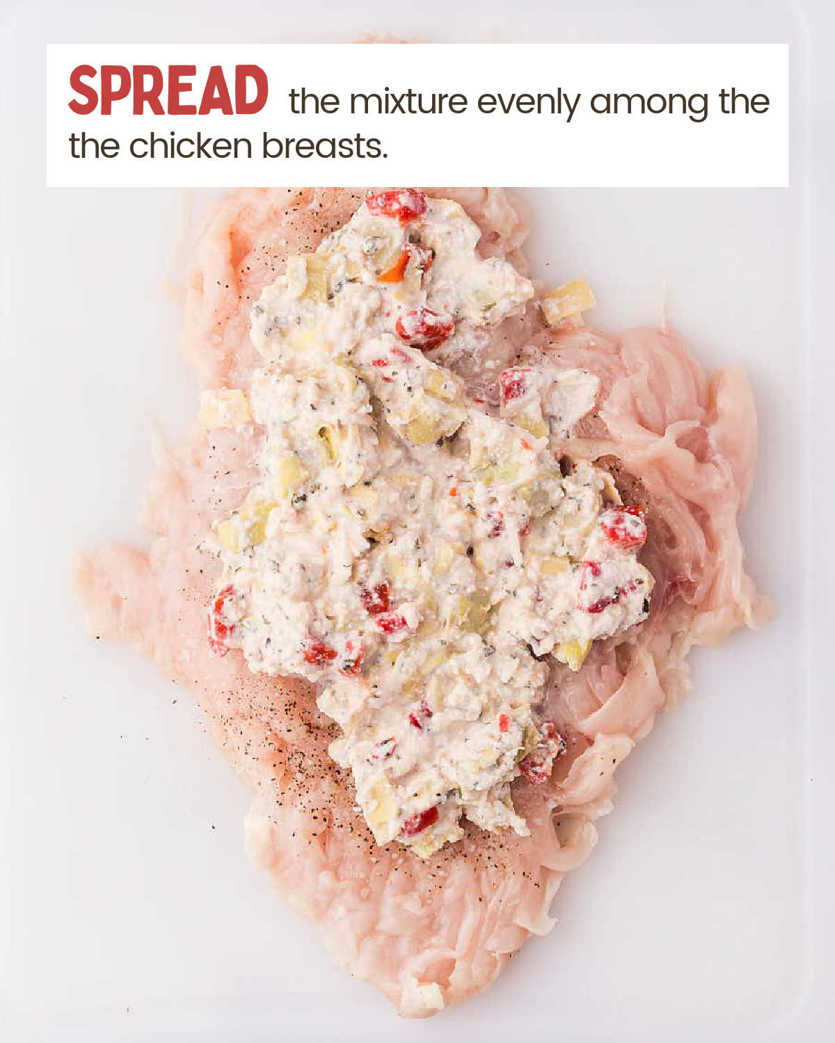Spreading the filling across the center of the seasoned chicken breast.