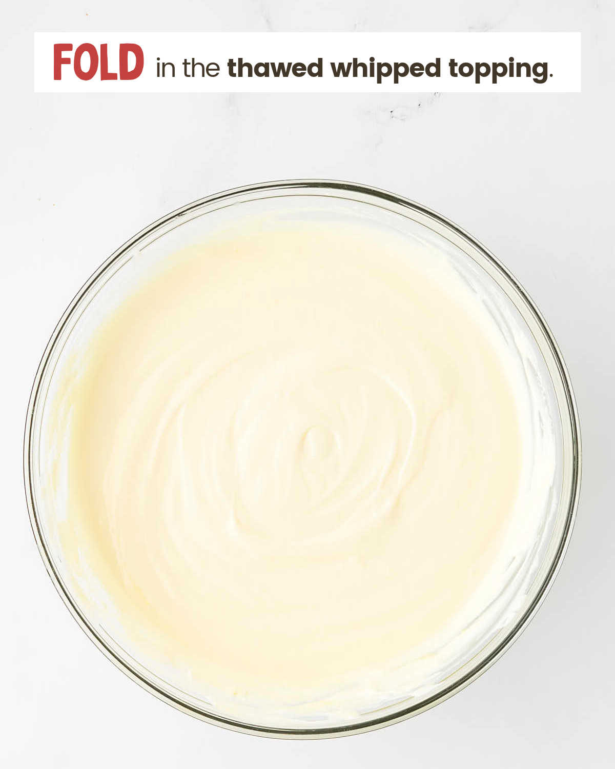Whipped topping mixed with milk and pudding mix in a bowl.