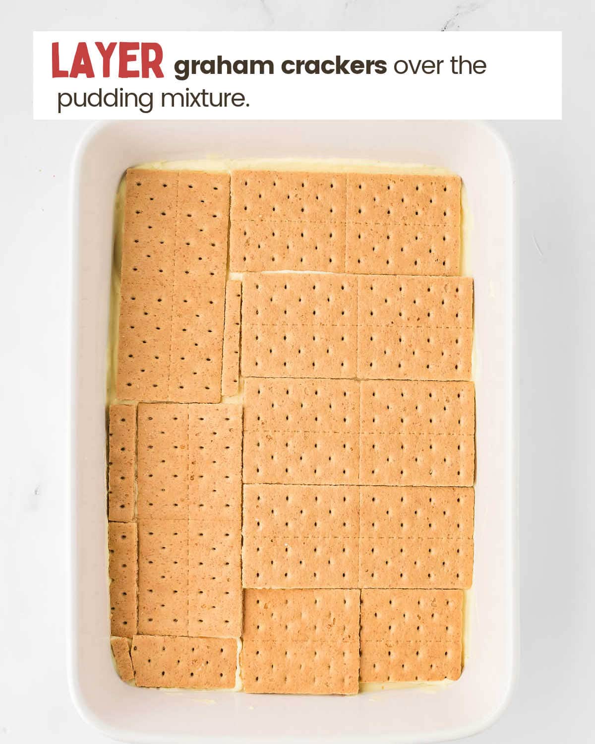 Graham crackers layered over a pudding mixture in a dish.