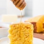 Drizzling honey over cornbread topped with a little bit of butter.