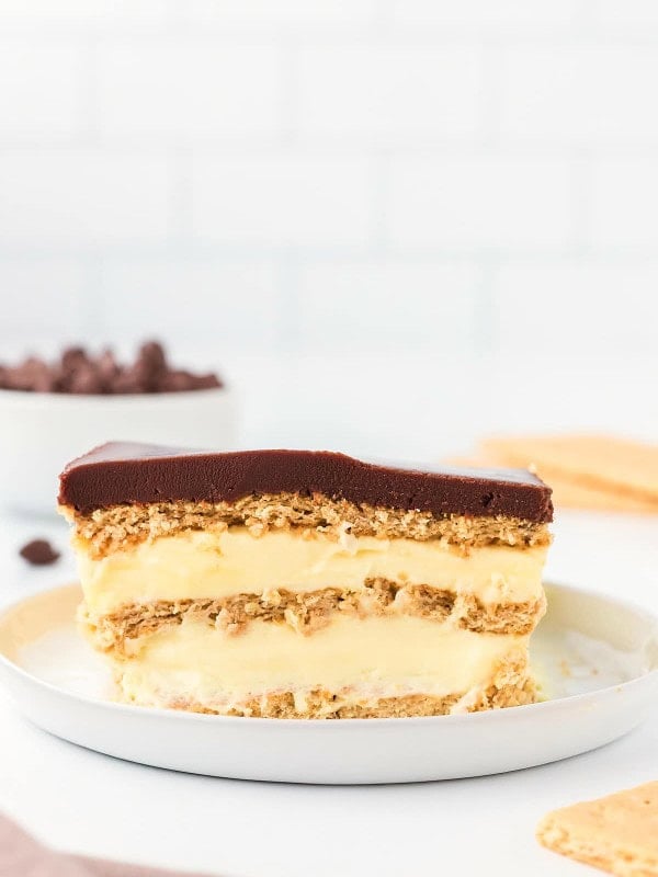 A slice of No-Bake Eclair Cake on a white plate.