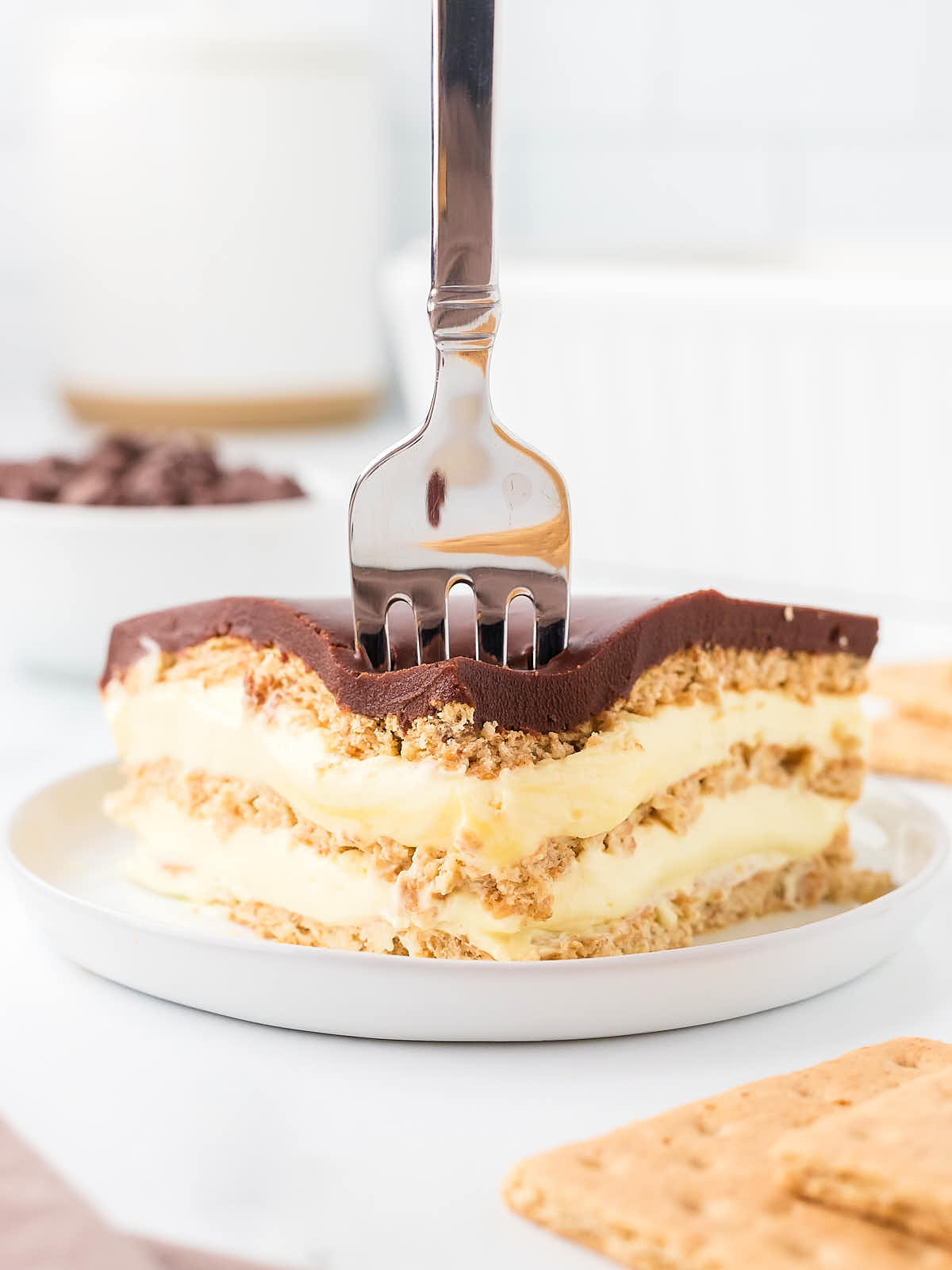 Digging a fork into a slice of Eclair Cake.