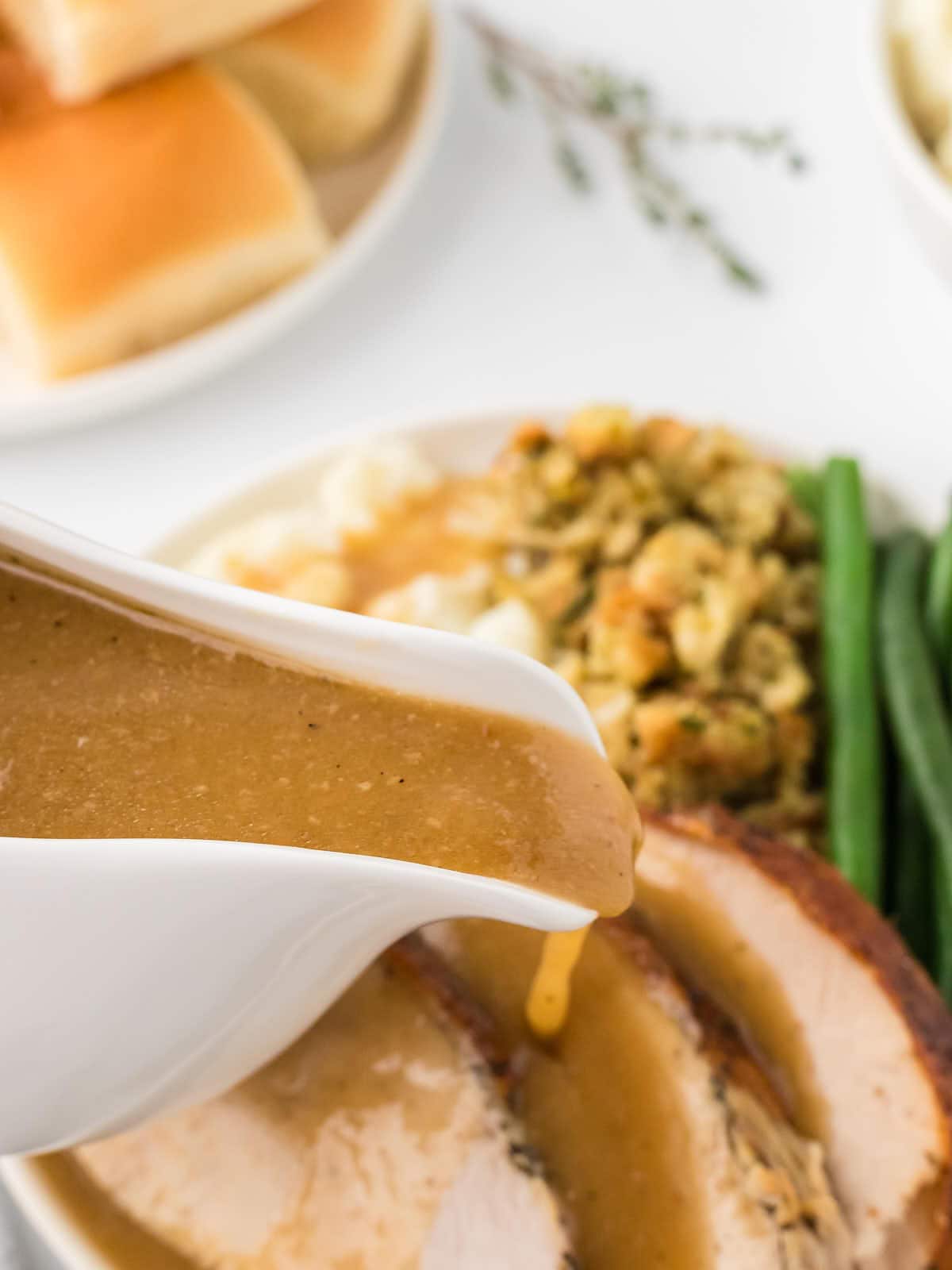 Pouring gravy over the sliced Turkey.