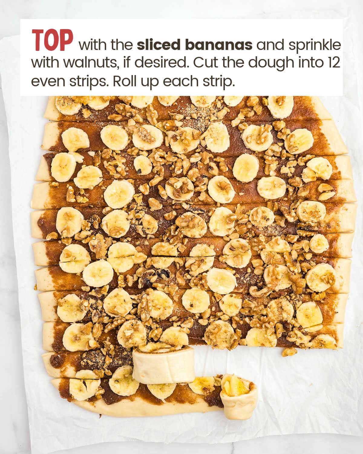 Sliced bananas and walnuts cover a piece of cinnamon dough.