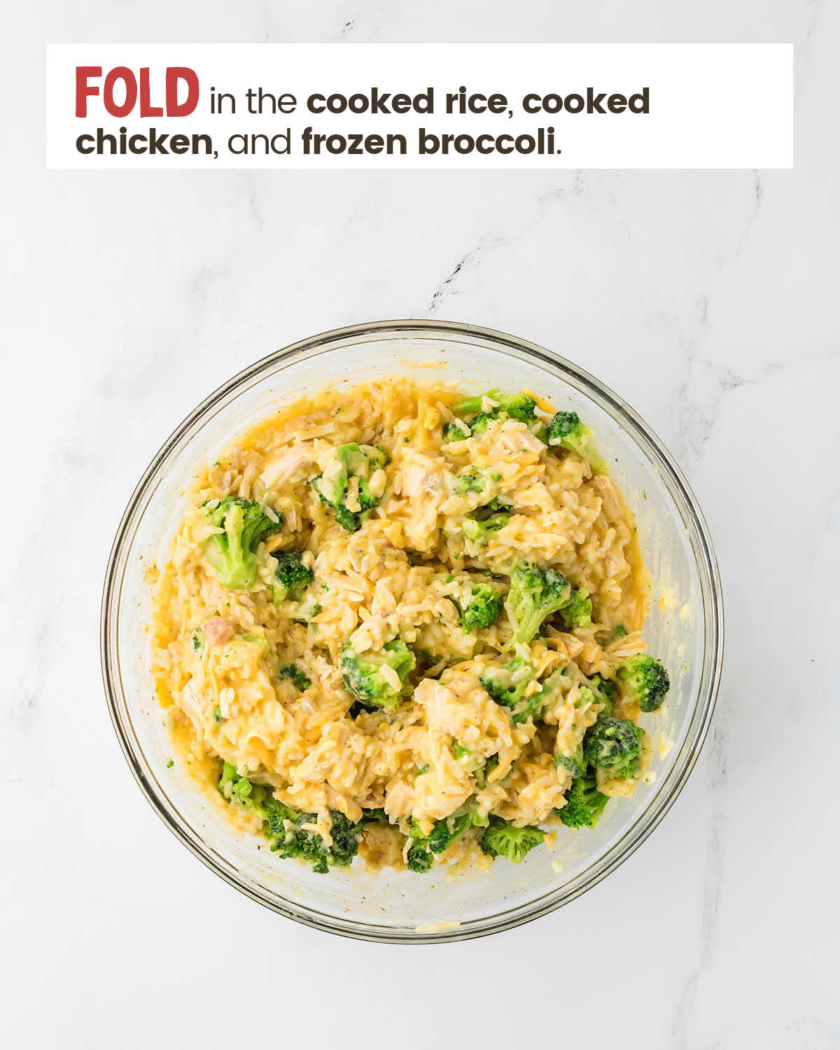 Soup mixture with cheese, frozen broccoli, and cooked chicken in a large bowl.