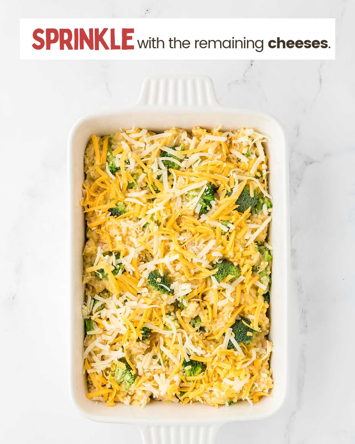 Chicken broccoli rice casserole sprinkled with cheese in a baking dish.