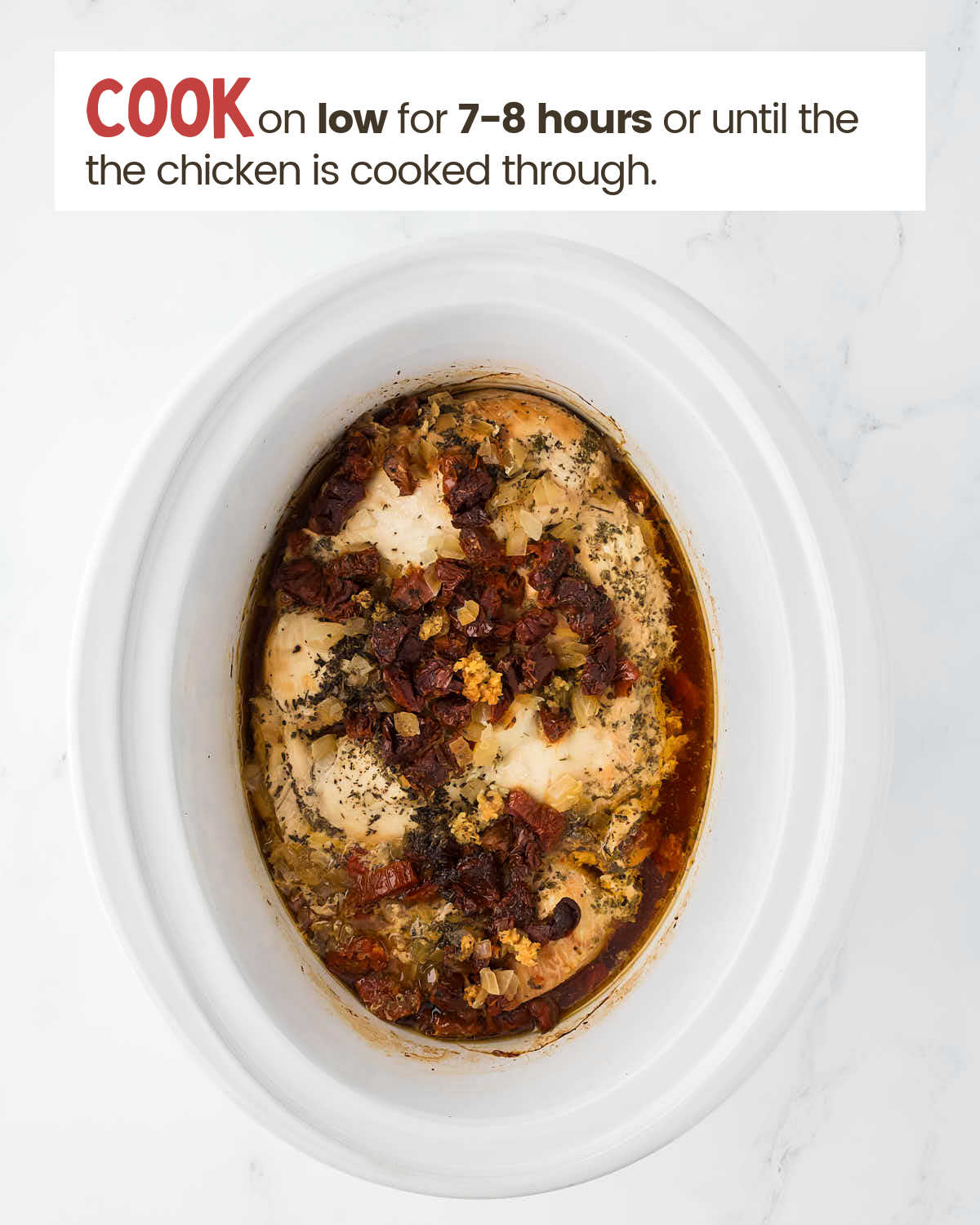 Chicken breasts with garlic and spices in a slow cooker covered with broth.