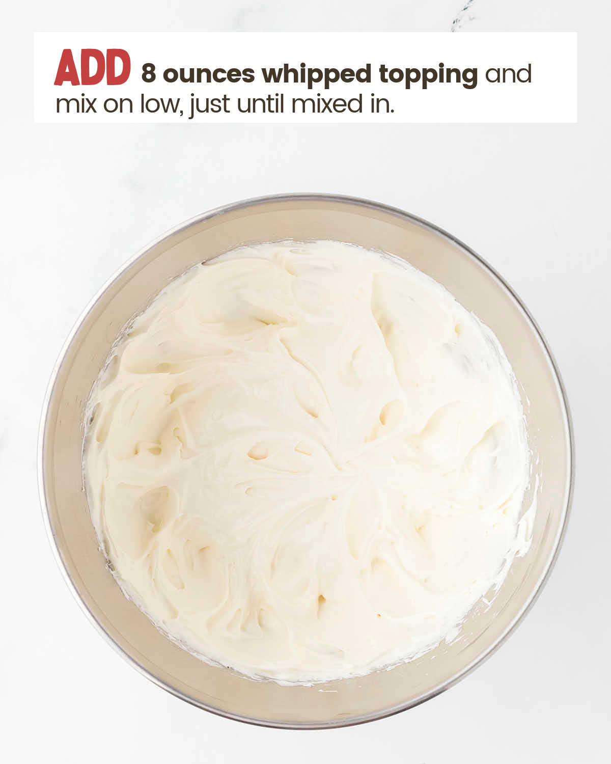 Cream cheese mixture in a bowl with whipped topping mixed in.