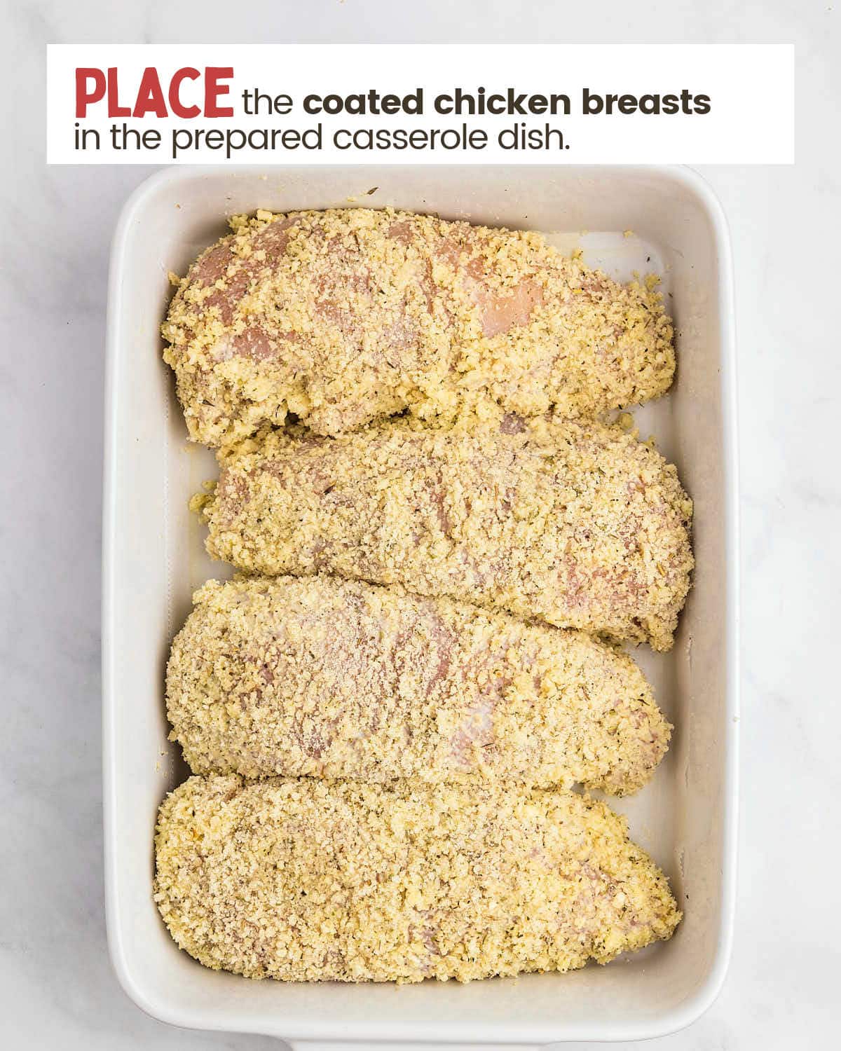 Chicken breasted coasted with parmesan breadcrumbs in a baking dish.