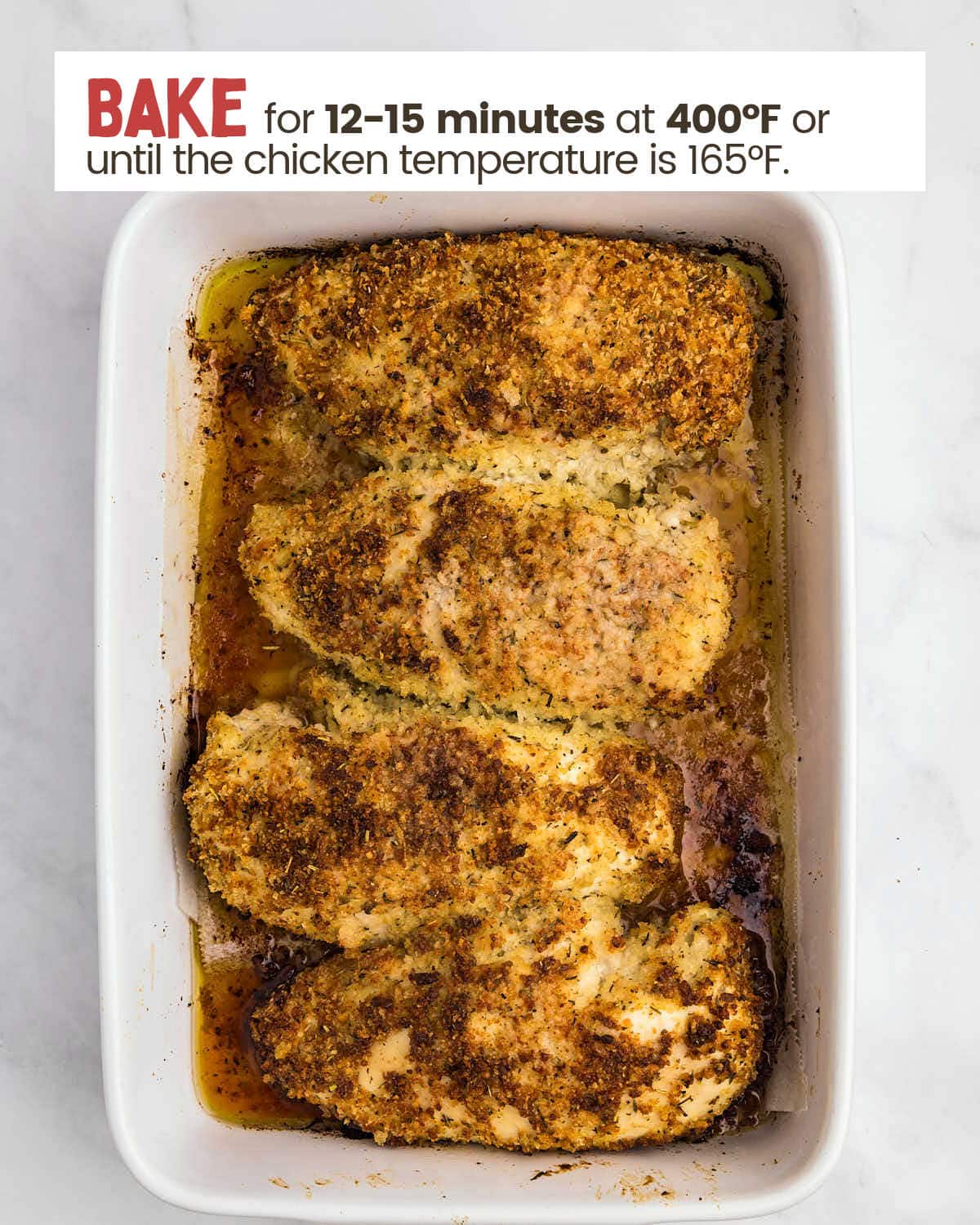 Baked parmesan crusted chicken breasts in a baking dish.