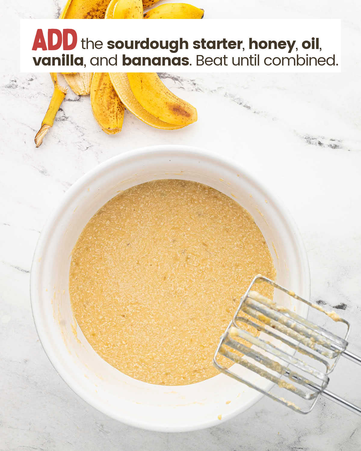 Peeled bananas above a bowl with a beaten mixture with beaters on edge of the bowl.