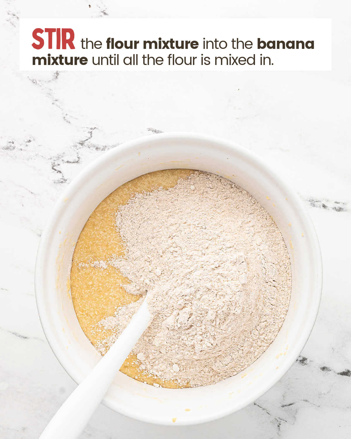 Flour mixture on top of beaten mixture with a spoon to stir them together.