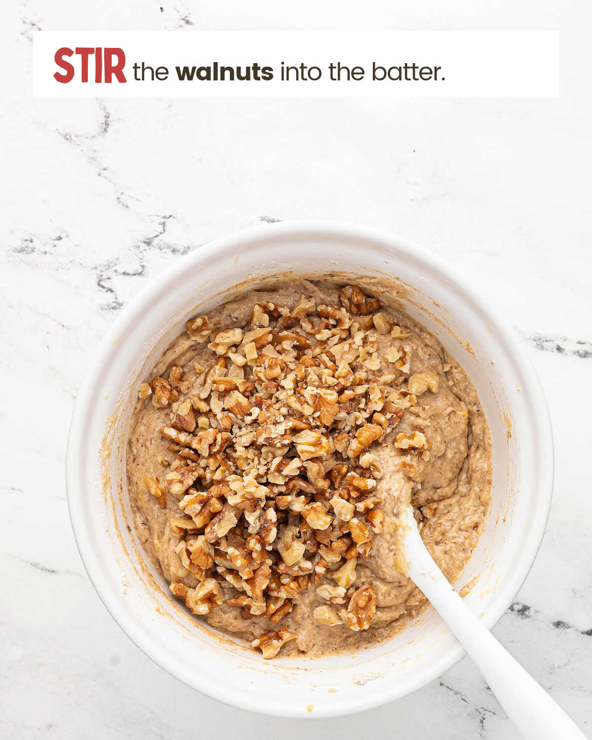 Walnuts being stirred into sourdough banana bread batter.