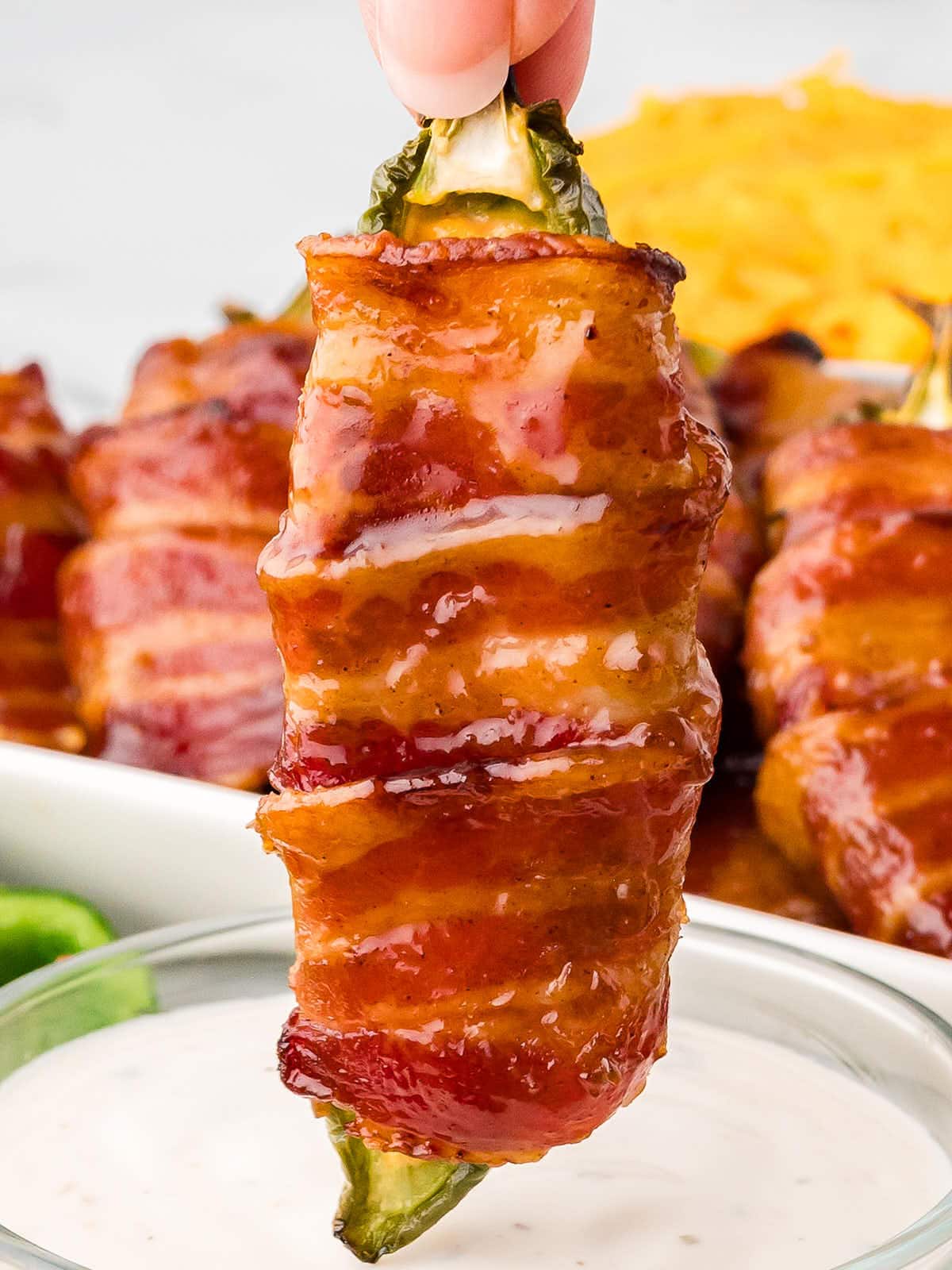 Dipping a Bacon Wrapped Jalapeno Poppers.