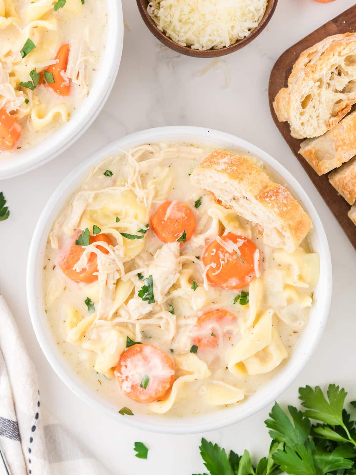 A topdown view of Chicken Tortellini Soup in a white bowl.