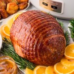 Crock Pot Ham on a white plate served with oranges and pineapples.