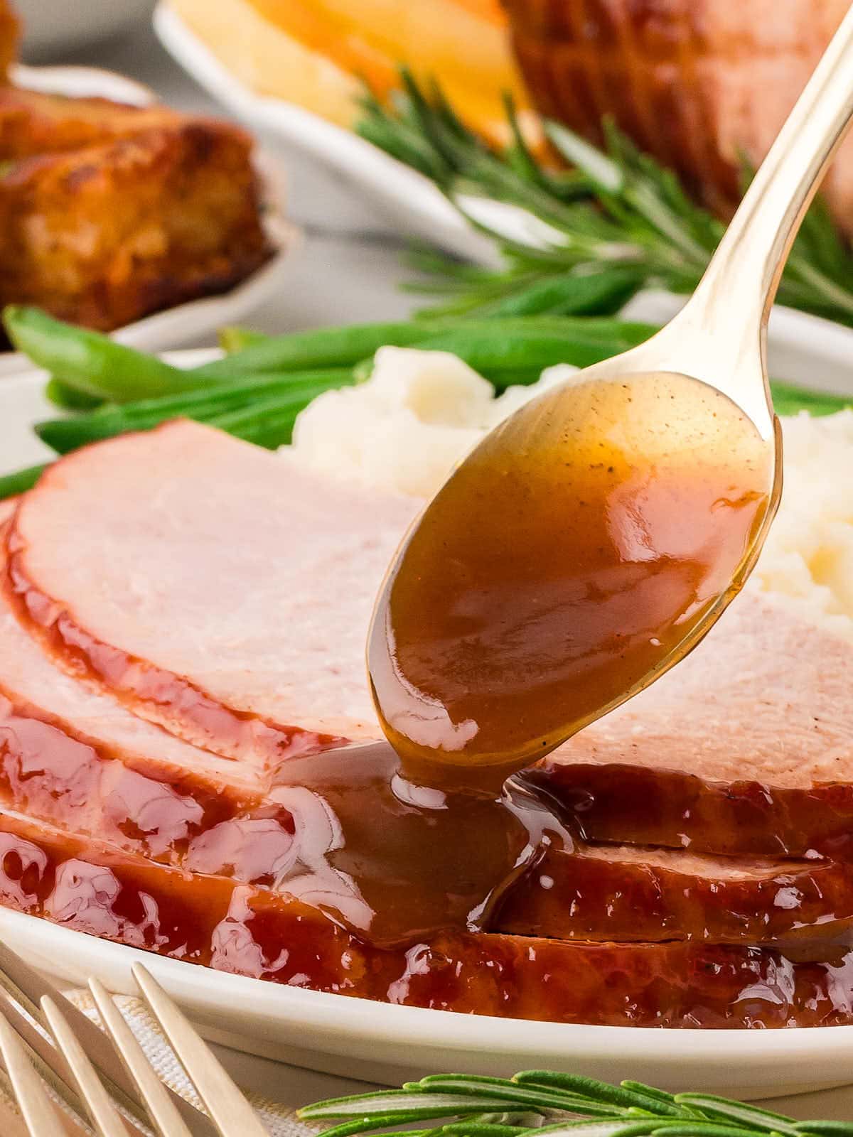 Pouring a glaze over the cooked ham.